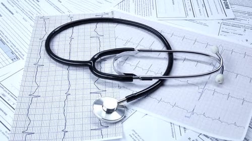 Stethoscope Resting on Medical Documents and EKG Report