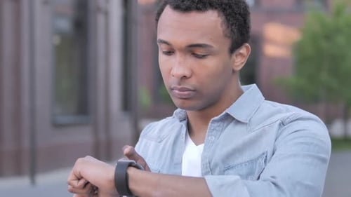 Young Adult Interacts with Smart Watch Outdoors