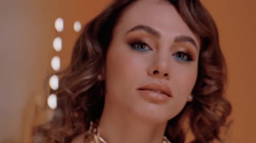 Glamorous Woman with Curly Hair and Gold Necklace