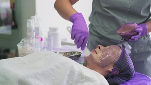 Woman Receives Facial Mask in Spa Environment