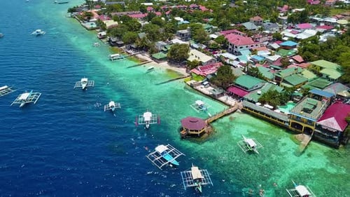 Tourists Swimming Around Bangka Boats Floating On Crystal Clear Blue Water In Moalboal Cebu