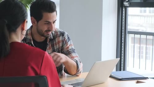 Adults Working Together on Laptop in Modern Office