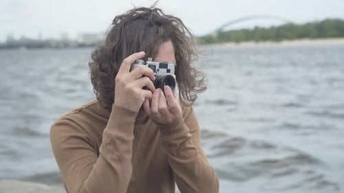 Photographer with Film Camera on Overcast Beach Day