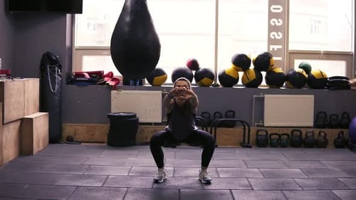 Fit Woman Doing Squats in Gym Environment