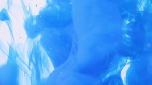 Nuvem de tinta azul pulverizada na água com glitter