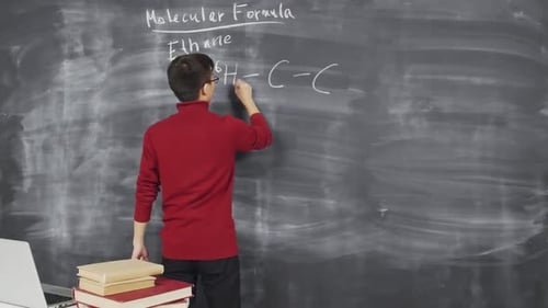 Chemiker schreibt Formel auf Tafel