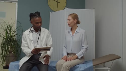 Doctor Sits with Patient in Examination Room