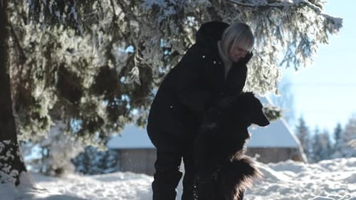Young Happy Woman Playing with a Cute Dog at Mountain on a Winter Day at Countryside, Outdoor