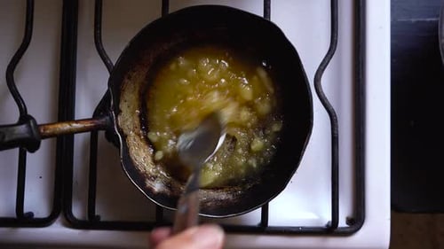 Stirring Yellow Food Mixture in Small Pan