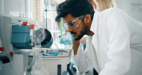 Man Analyzing Scientific Equipment in Modern Laboratory