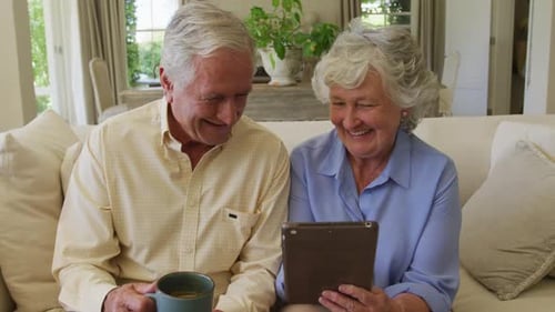 Senior Couple Relaxing with Tablet at Home
