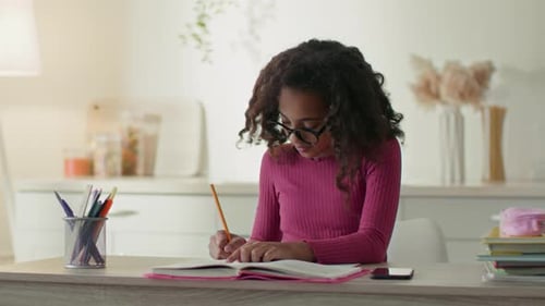 Student Focused on Homework at Bright Desk