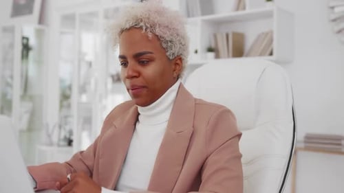 Attractive African American Woman Leans Back in Office Chair Pulling Up