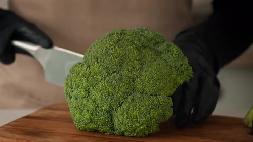 Cook Cutting Broccoli Into Florets Cooking Wearing Gloves Indoors Closeup