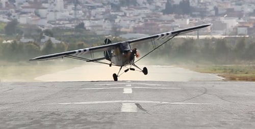 Small Plane Landing on Rural Airstrip During Day