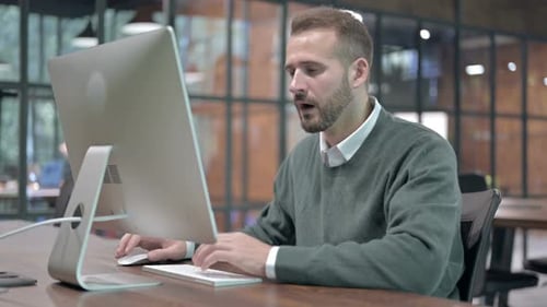 Gestresster Mann wird bei der Arbeit am Computer schockiert