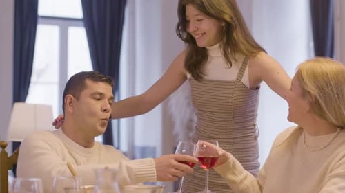 Happy Teen Hugs and Kisses Father at Dinner