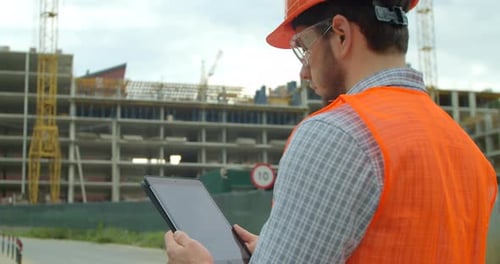 Moderner Bauingenieur oder Architekt mit Helm auf der Baustelle arbeitet mit Industrial