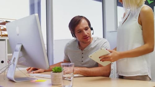 Führungskräfte interagieren bei der Arbeit an Computer und digitalem Tablet 4k