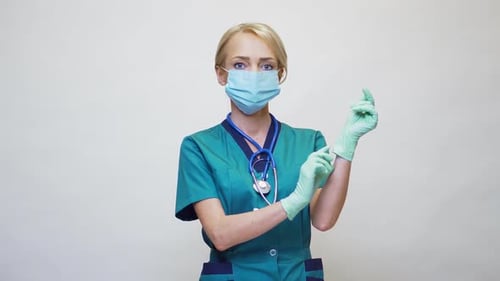 Woman Doctor in Scrubs Putting on Surgical Gloves