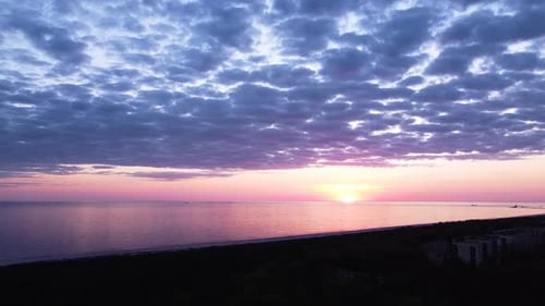 Beautiful aerial vibrant high contrast pink purple sunset with blue clouds over Baltic sea at Liepaj