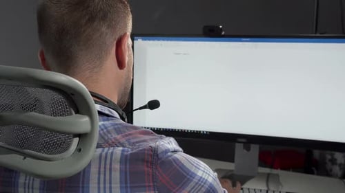 Handsome Call Center Operator Smiling To the Camera After Typing on His Computer