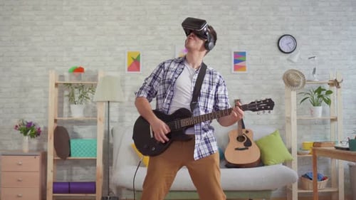 Young Adult Playing Guitar with VR Headset