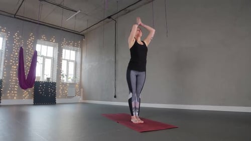 Yoga à l'intérieur une femme en plastique se penche et s'enroule autour de sa jambe