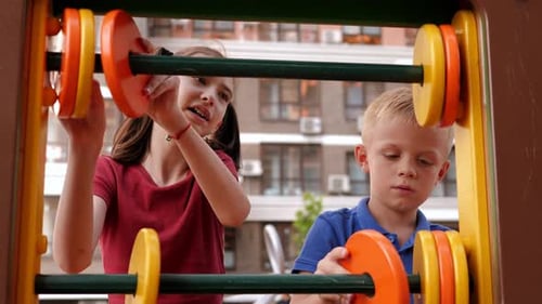 Ein Junge und ein Mädchen lernen auf dem Spielplatz zu zählen