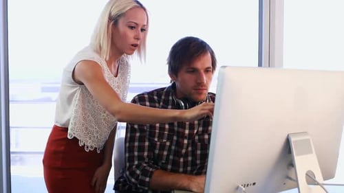 Colleagues Collaborate at Computer in Modern Office