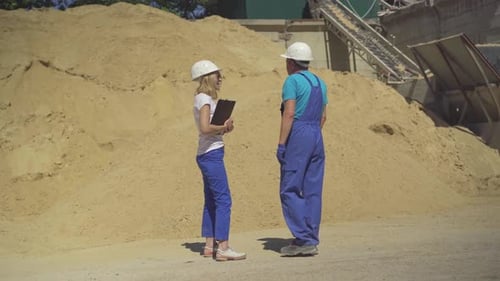 Wide Shot of Professional Female Inspector and Male Worker Standing on Manufacturing Site in Front