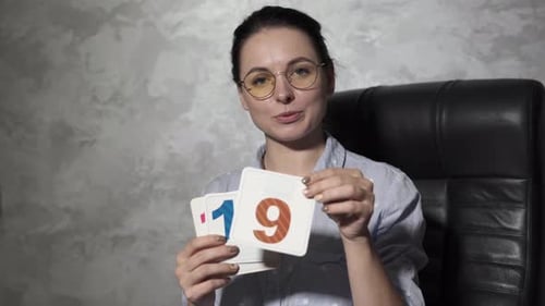 Young Woman Holds Up Number Flashcards