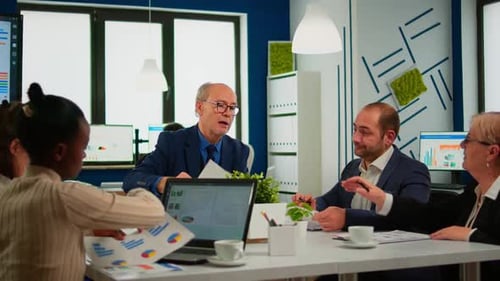 Senior Businessman Team Leader Brainstorming with Colleague Using Paperwork