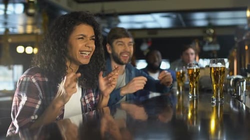 Biracial Girl With Friends Watching Sport Game in Bar, Happy Time Together