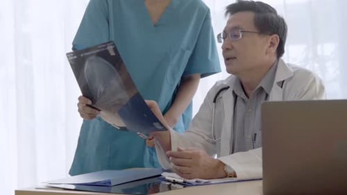 Doctors Discussing X-Ray in Bright Office Setting