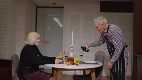 Senior Couple Sharing Romantic Meal in Kitchen