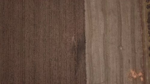 a Large Tractor Plows a Field