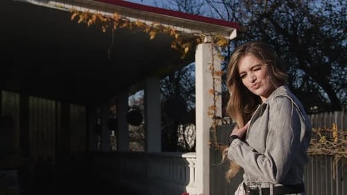 Schönes modisches Modell, sanftes Lächeln, posiert im Freien. Charmanter blonder Look in Zeitlupe