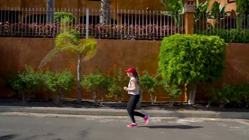 Woman Runs Down the Street Among the Palm Trees