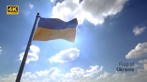 Ukrainian Flag Waving Against Blue Sky with Sunflare