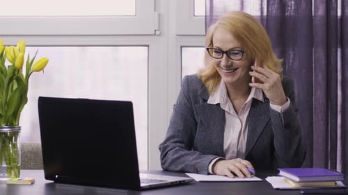 Business Woman on Phone at Desk with Laptop