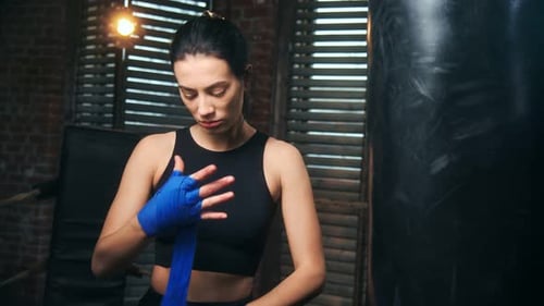 Athletic Woman Wrapping Hands for Boxing Workout
