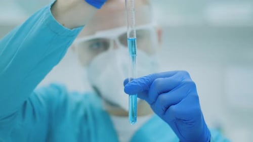 Lab Worker Testing Blue Liquid in Test Tube