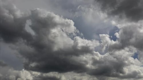 ein langer 4k-Zeitraffer aus sich schnell bewegenden und dramatisch Cumuluswolken am Nachmittag, die sich von rechts nach links