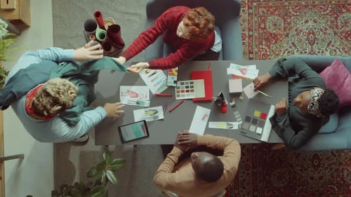 Team of Fashion Designer Discussing Clothes at Meeting