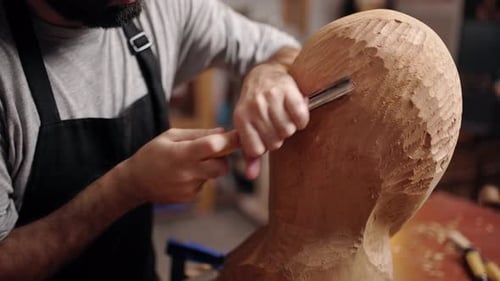 Artist Carving Wooden Sculpture Head in Workshop