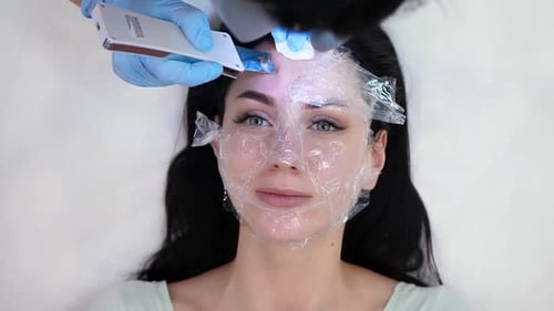 Woman Receiving Facial Treatment With Electrical Device