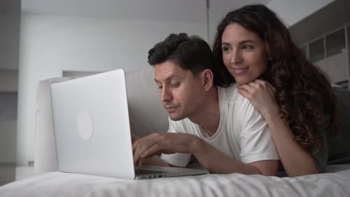 Couple Using Laptop Together on Couch at Home