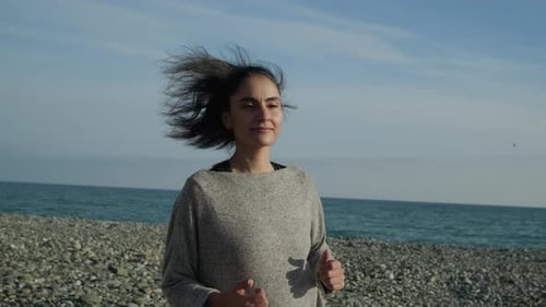 Smiling Woman Running on Beach