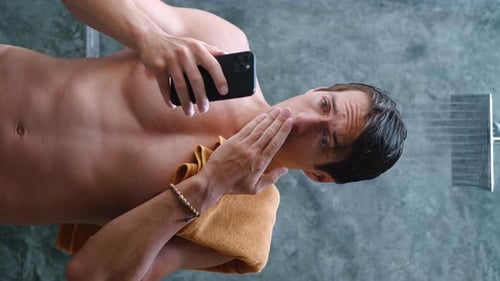 Young Man Reacting to Phone in Shower